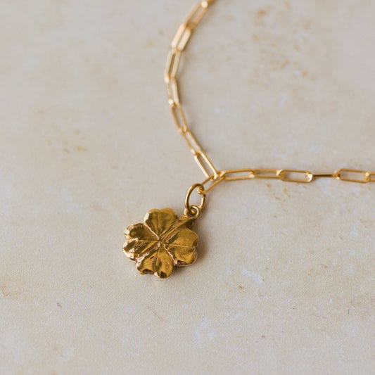 close-up of 18ct gold vermeil four-leaf clover bracelet on paperclip chain by Iris & Lolli