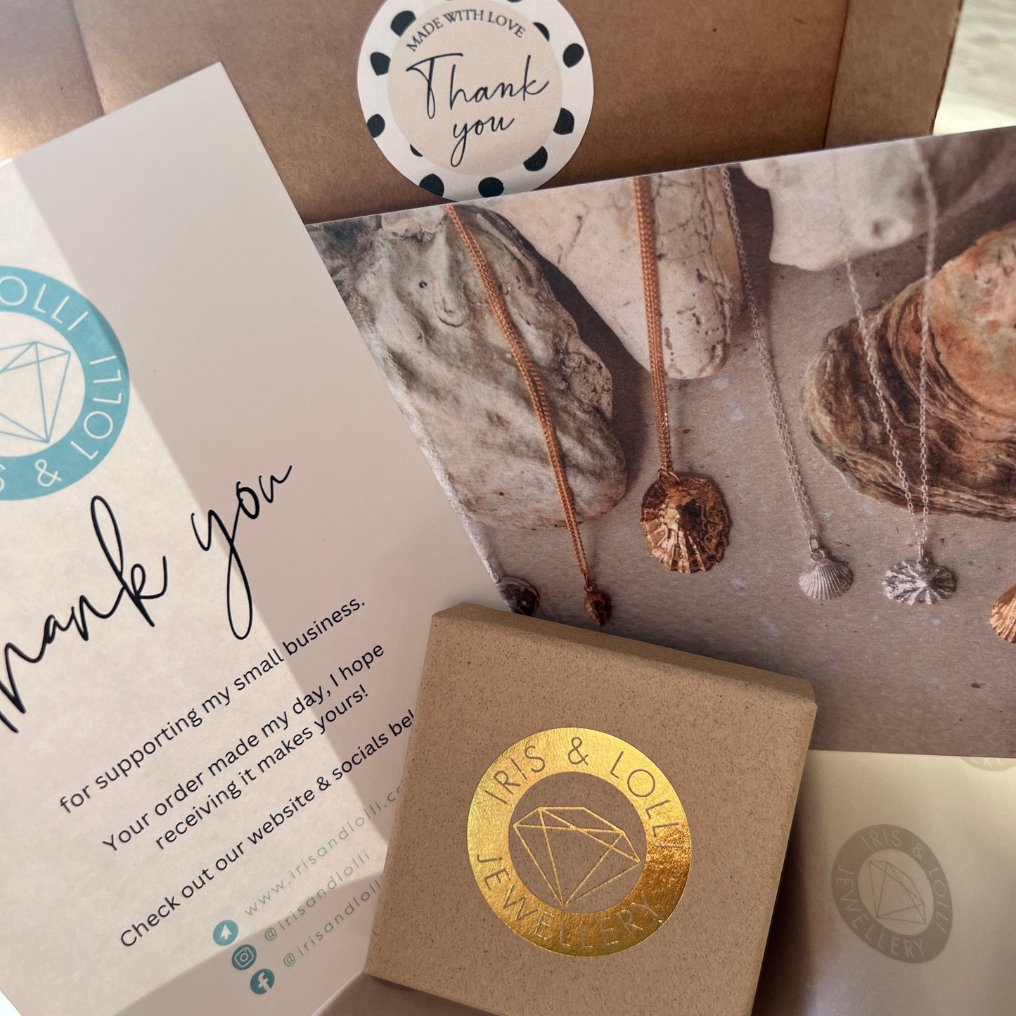 Jewelry packaging with 'Iris & Lolly' branding, including a card and box.