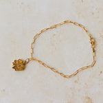 18ct gold vermeil four-leaf clover bracelet with paperclip chain on neutral background by Iris & Lolli