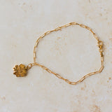 18ct gold vermeil four-leaf clover bracelet with paperclip chain on neutral background by Iris & Lolli