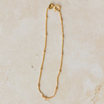 18ct gold vermeil satellite chain bracelet with delicate gold bead accents displayed on neutral background by Iris & Lolli