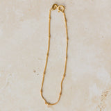 18ct gold vermeil satellite chain bracelet with delicate gold bead accents displayed on neutral background by Iris & Lolli