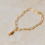 18ct gold vermeil whelk shell charm bracelet with paperclip chain displayed on neutral background by Iris & Lolli