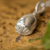 Silver necklace with a pendant on a textured surface