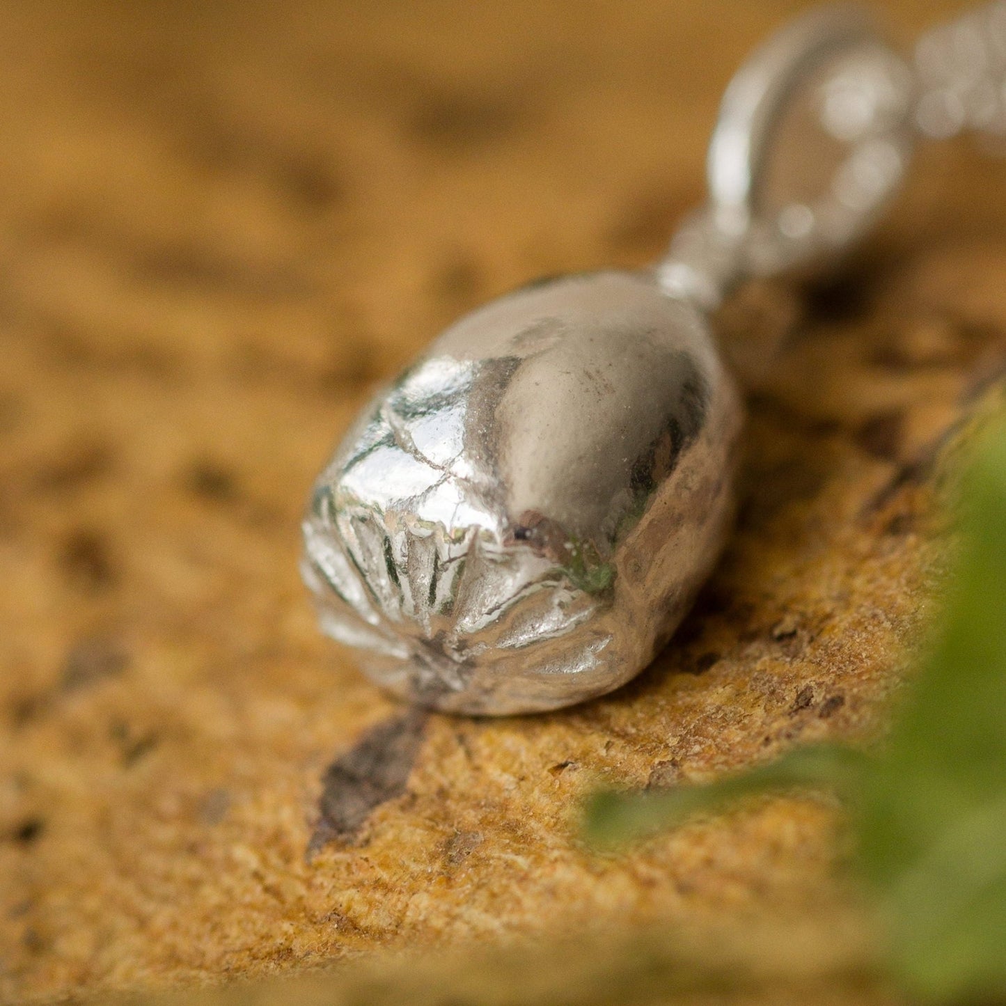 Silver necklace with a pendant on a textured surface