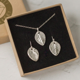 Handmade silver rose leaf necklace and earring set displayed in eco-friendly gift packaging