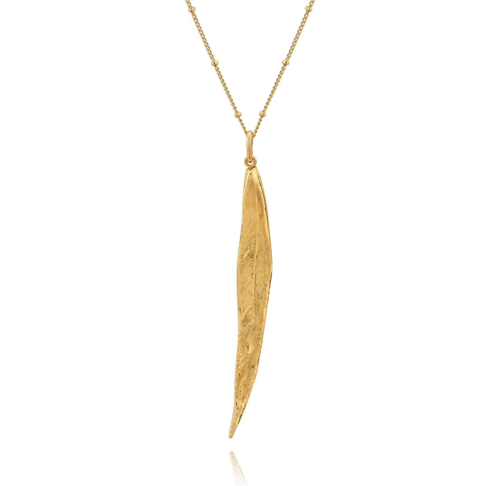 Gold necklace with a leaf pendant on a white background