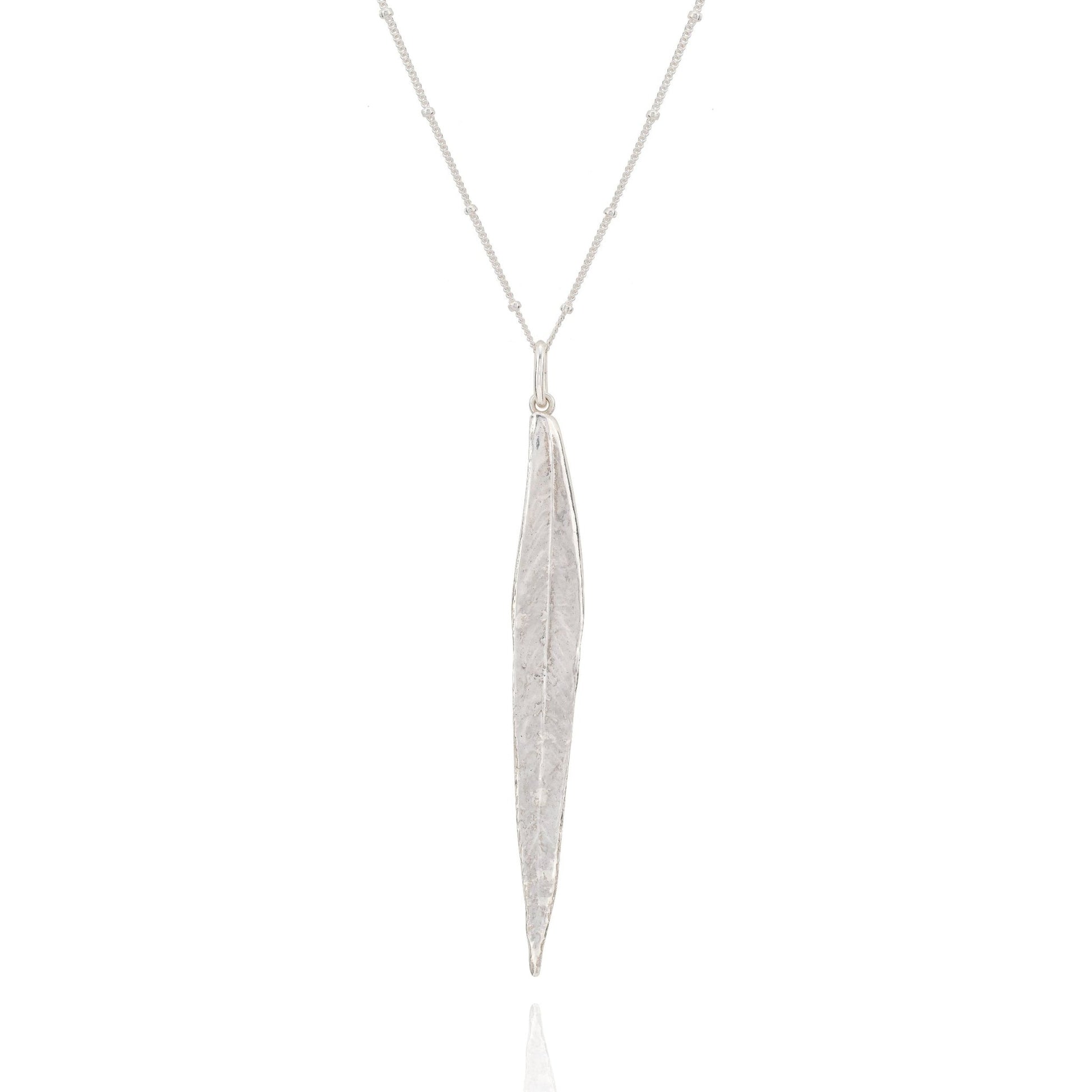 Silver necklace with a long, thin pendant on a white background