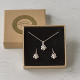 Silver forget me not necklace and earrings set shown together in a jewellery gift box