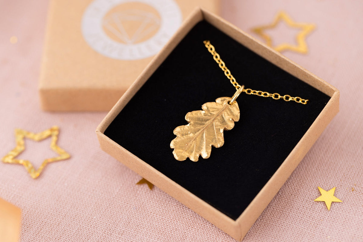 Gold oak leaf necklace in an Iris & Lolli gift box with festive stars