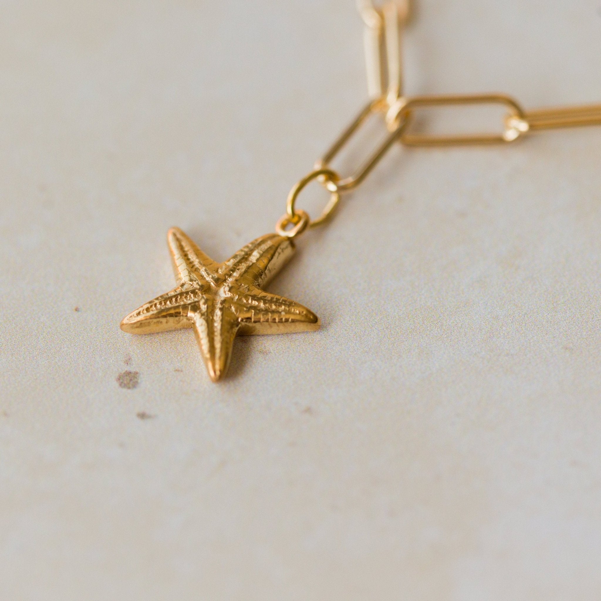 close up of gold vermeil starfish charm on paperclip chain bracelet, handcrafted ocean inspired design by Iris & Lolli
