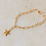 gold vermeil starfish charm bracelet with paperclip chain displayed on sandy neutral background by Iris & Lolli