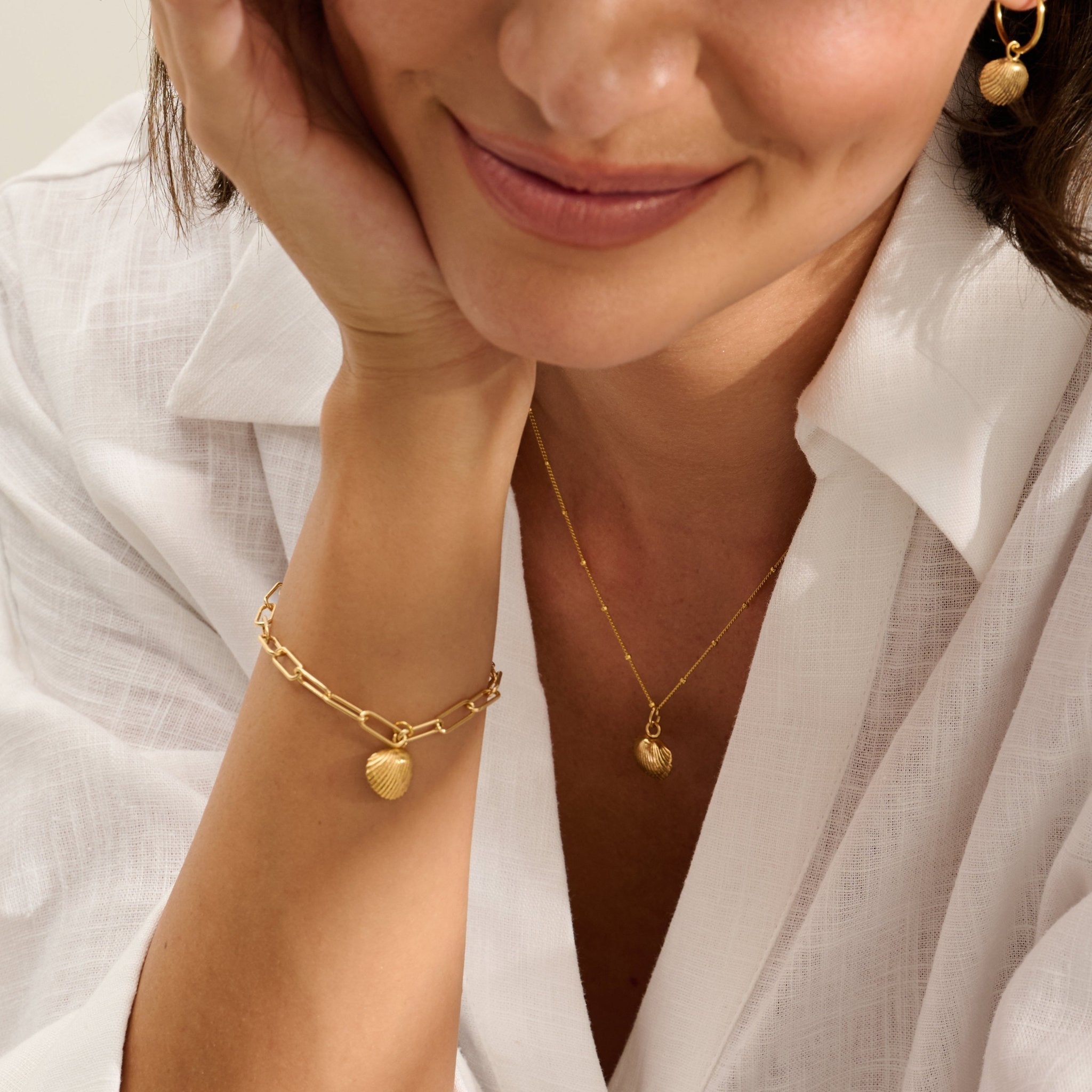 Model wearing Iris & Lolli Gold Cockle Shell Necklace with matching Gold Cockle Shell Earrings and Gold Cockle Shell Charm Bracelet handcrafted from recycled silver with 18ct gold vermeil finish