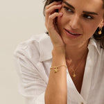 Model wearing Iris & Lolli Gold Starfish Necklace with matching Gold Starfish Charm Bracelet and Gold Cockle Shell Earrings handcrafted from recycled silver with 18ct gold vermeil finish