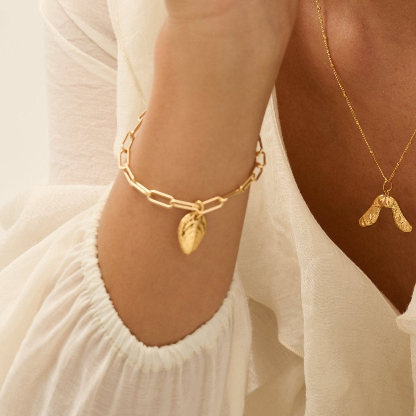 Model wearing Iris & Lolli Gold Sycamore Seed Necklace with Gold Earrings and Gold rose leaf Bracelet handcrafted from recycled silver with 18ct gold vermeil finish