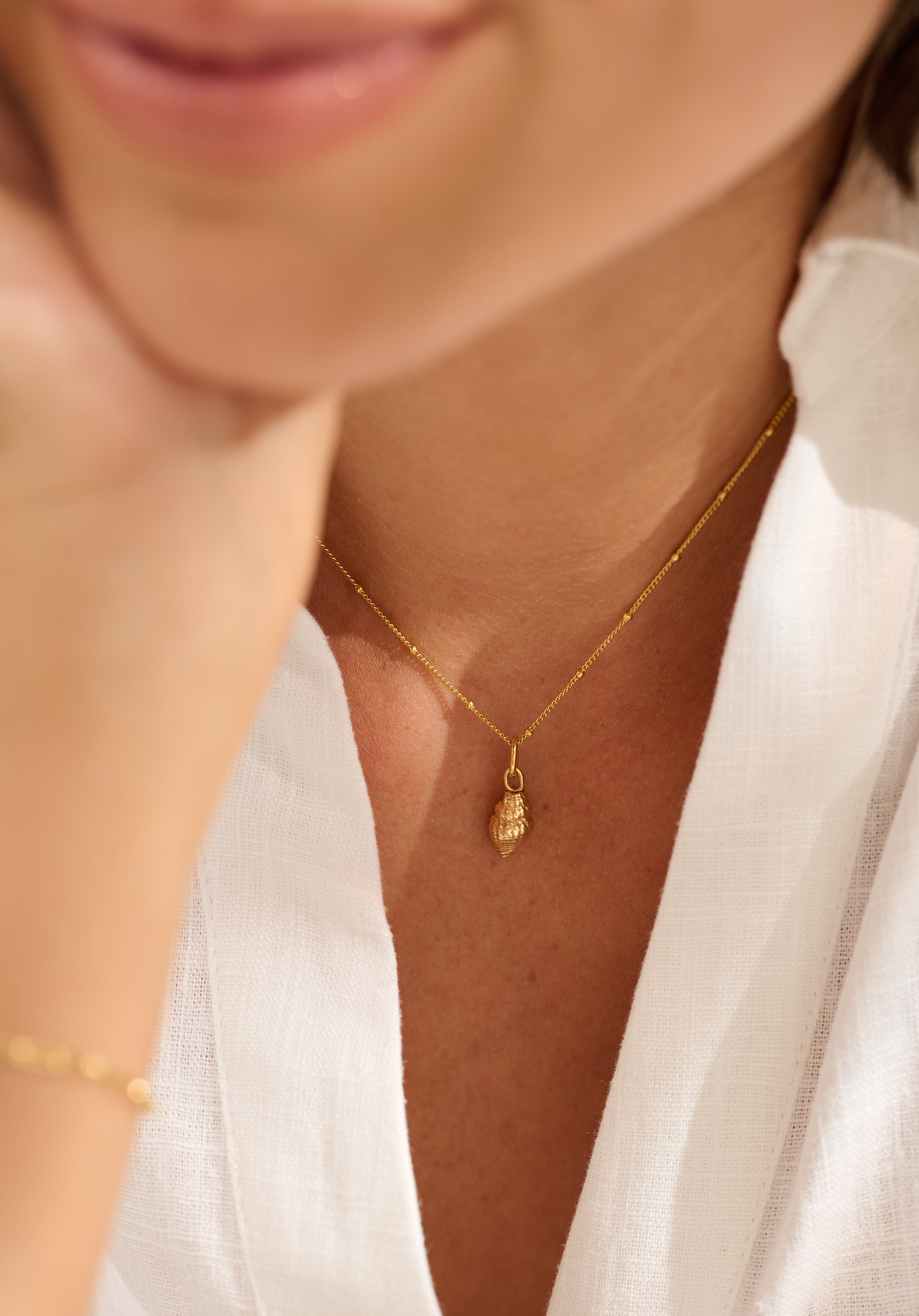 Model wearing Iris & Lolli Gold Whelk Shell Necklace handcrafted in recycled silver with 18ct gold vermeil finish