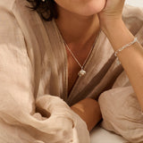 Model wearing Iris & Lolli Silver Limpet Shell Necklace paired with Silver Charm Bracelet, both handcrafted from recycled silver with natural coastal texture