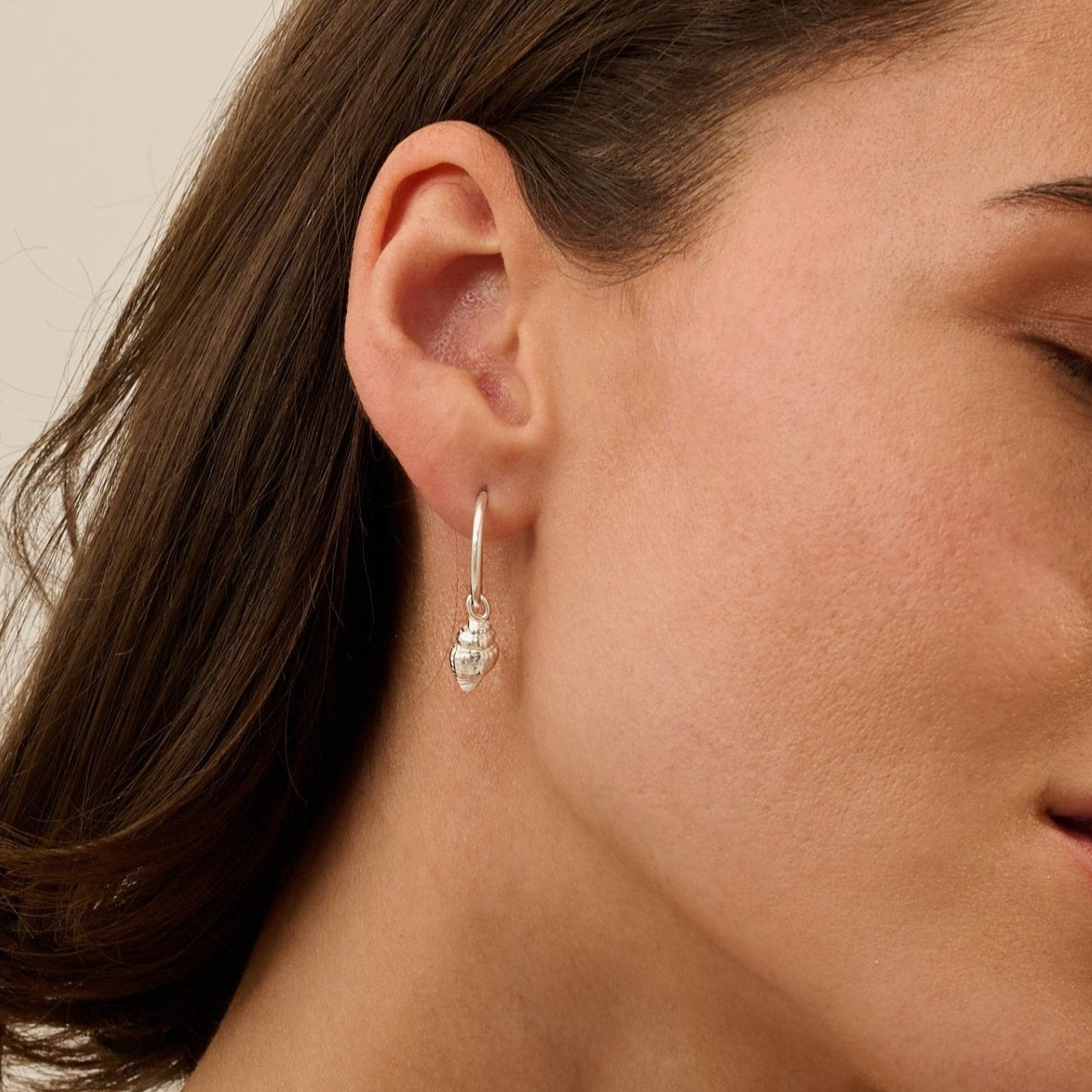 Model wearing Iris & Lolli Silver Whelk Shell Earrings handcrafted from recycled silver with natural shell texture and polished finish