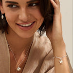 model wearing recycled silver starfish charm bracelet and Venus clam necklace by Iris & Lolli