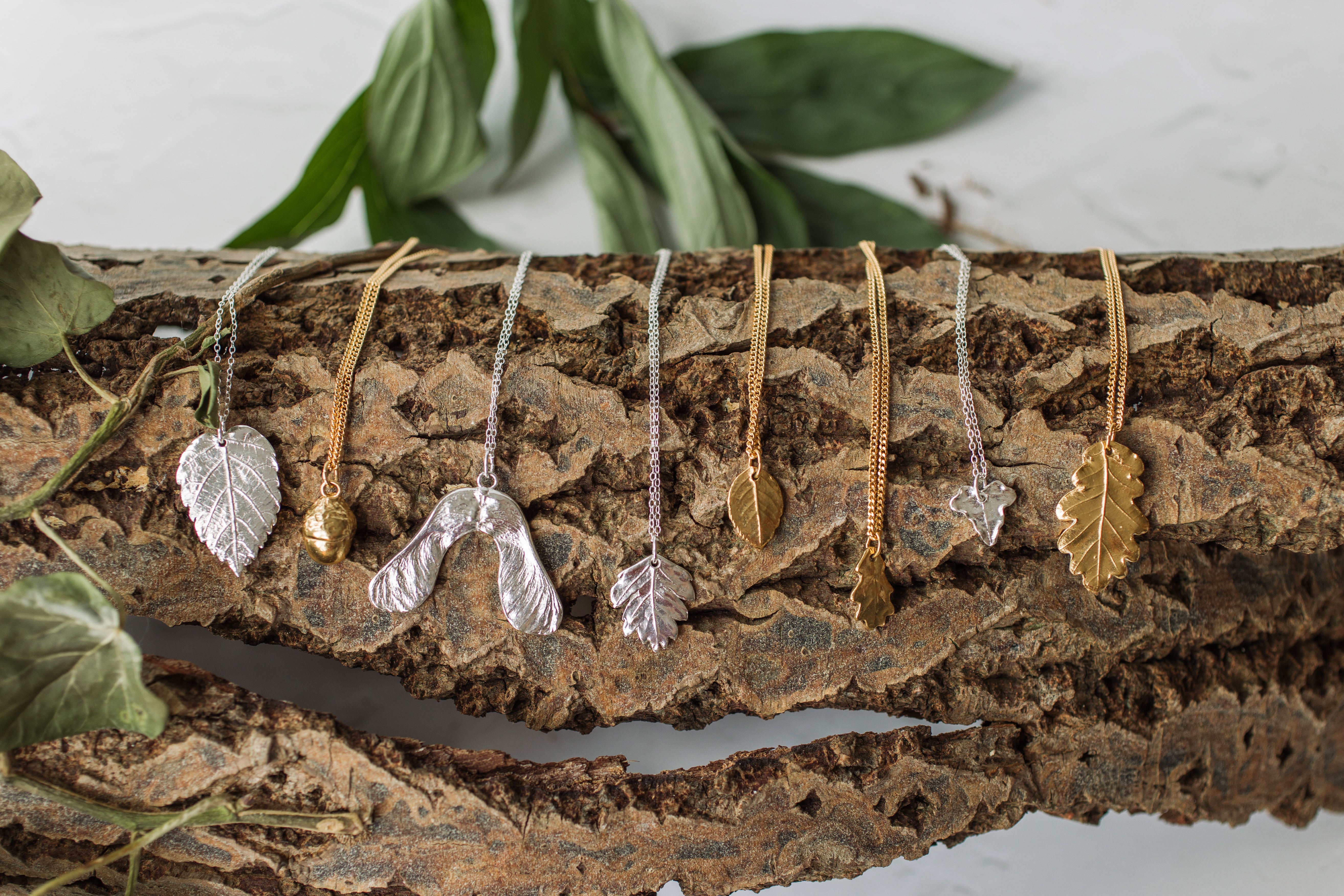 Iris & Lolli woodland jewellery in silver and gold displayed on bark
