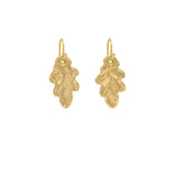 Handmade recycled gold small oak leaf drop earrings by Iris and Lolli on white background, nature inspired and crafted in the UK