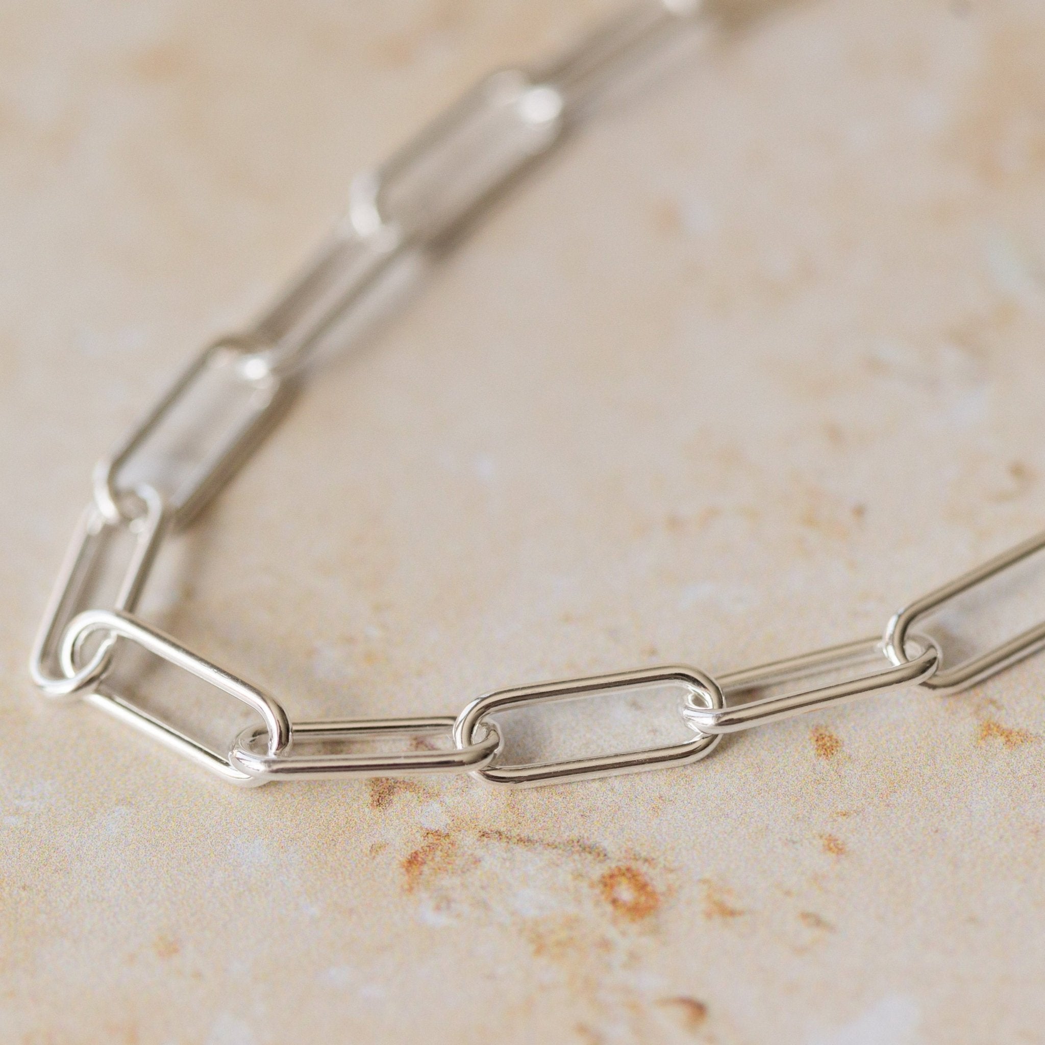 close-up of recycled silver chunky paperclip chain bracelet links on neutral background by Iris & Lolli