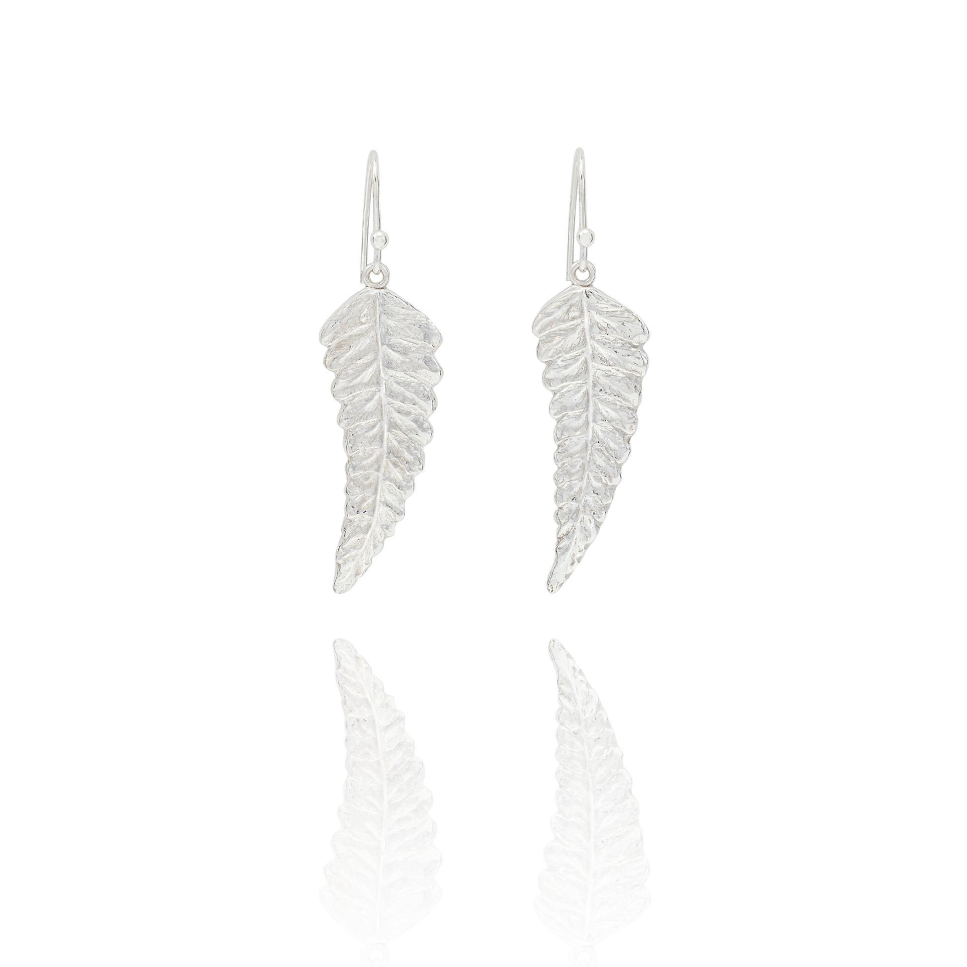 Handmade recycled silver fern leaf drop earrings by Iris and Lolli on white background, nature inspired and crafted in the UK