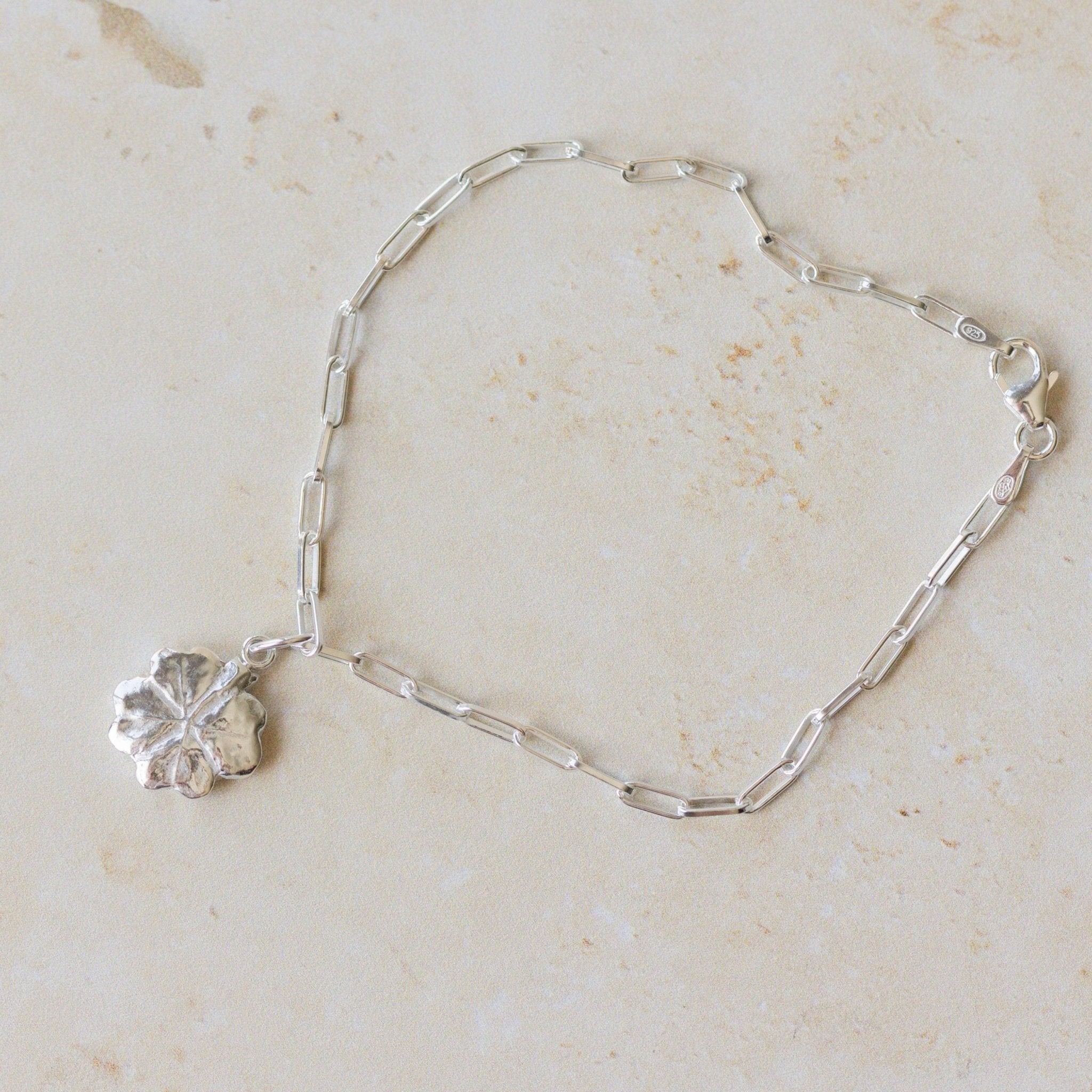 recycled silver four-leaf clover bracelet with paperclip chain displayed on neutral background by Iris & Lolli