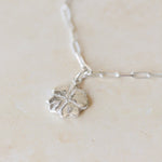 close-up of recycled silver four-leaf clover bracelet on paperclip chain by Iris & Lolli
