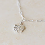 close-up of recycled silver four-leaf clover bracelet on paperclip chain by Iris & Lolli