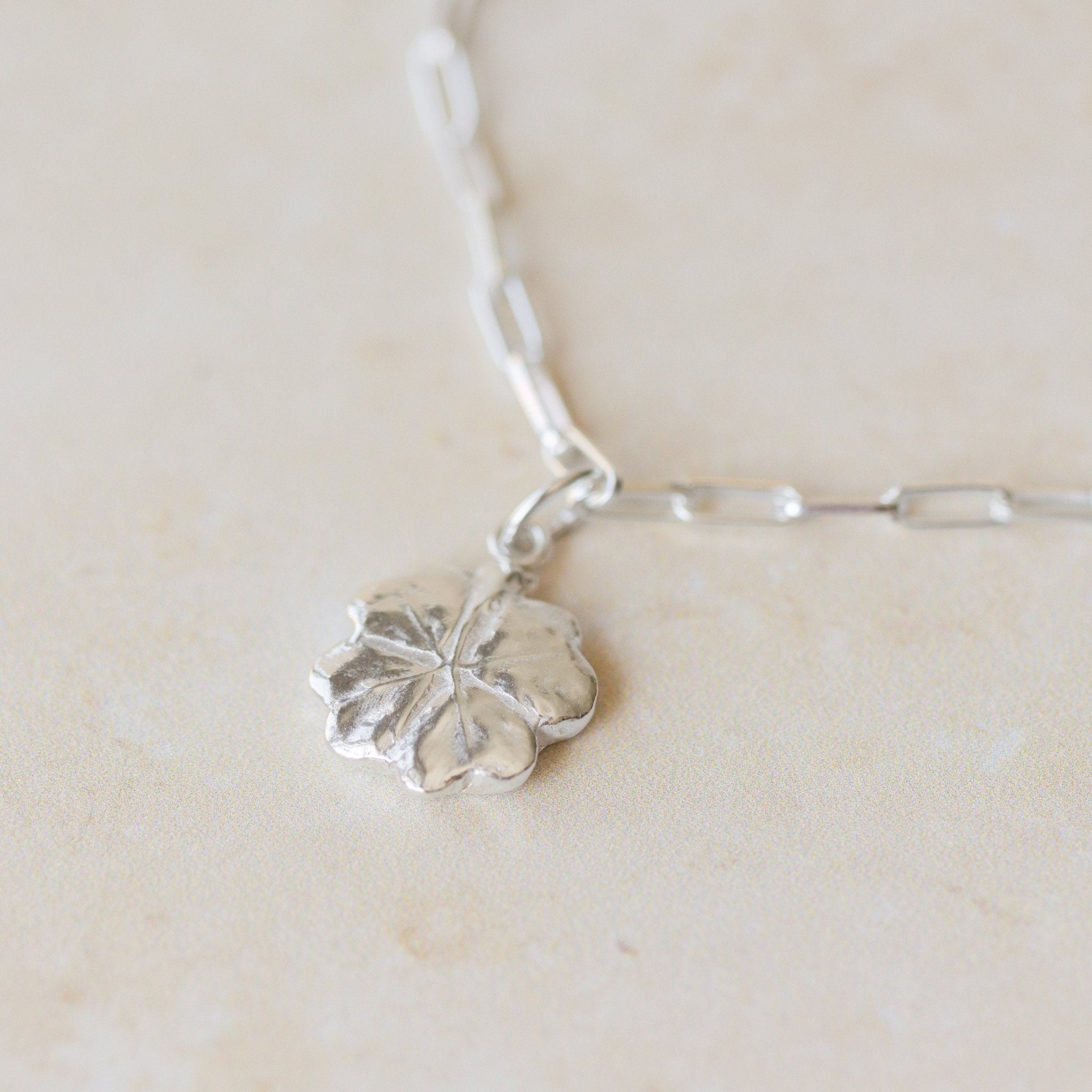 close-up of recycled silver four-leaf clover bracelet on paperclip chain by Iris & Lolli