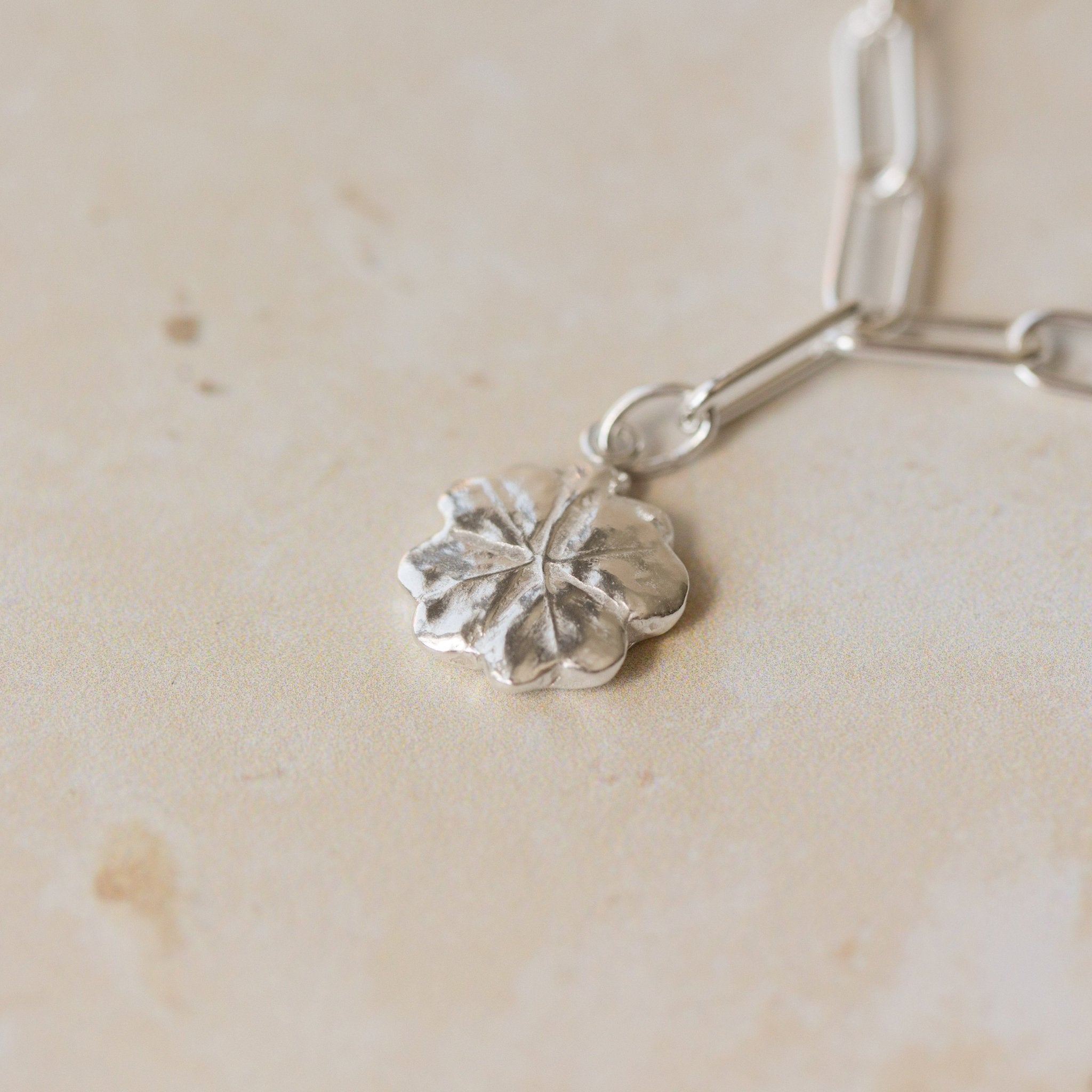 close-up of recycled silver four-leaf clover charm bracelet on paperclip chain by Iris & Lolli