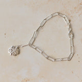 recycled silver four-leaf clover bracelet with paperclip chain on neutral background by Iris & Lolli