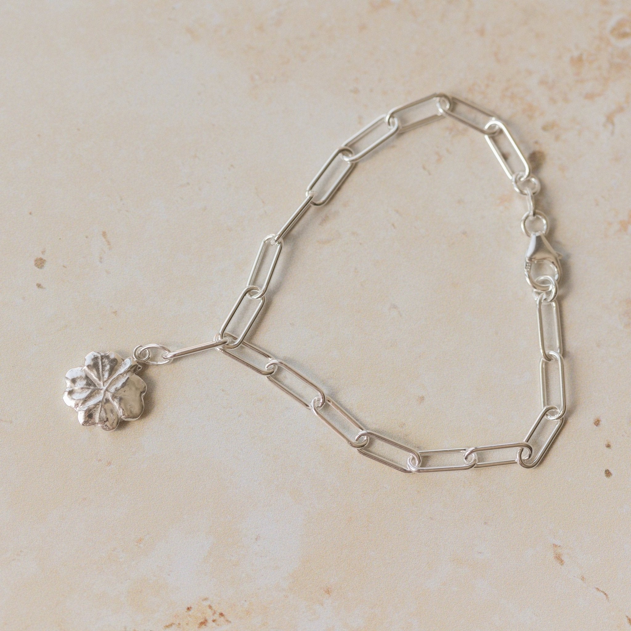 recycled silver four-leaf clover bracelet with paperclip chain on neutral background by Iris & Lolli