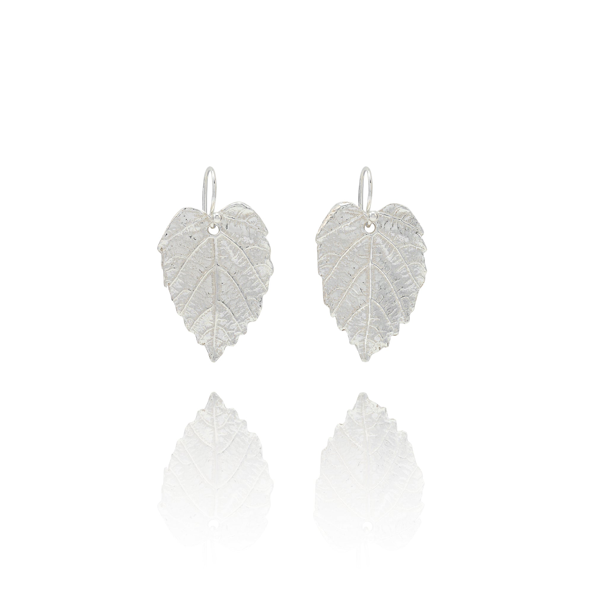 Handmade recycled silver hazel leaf drop earrings by Iris and Lolli on white background, nature inspired and crafted in the UK