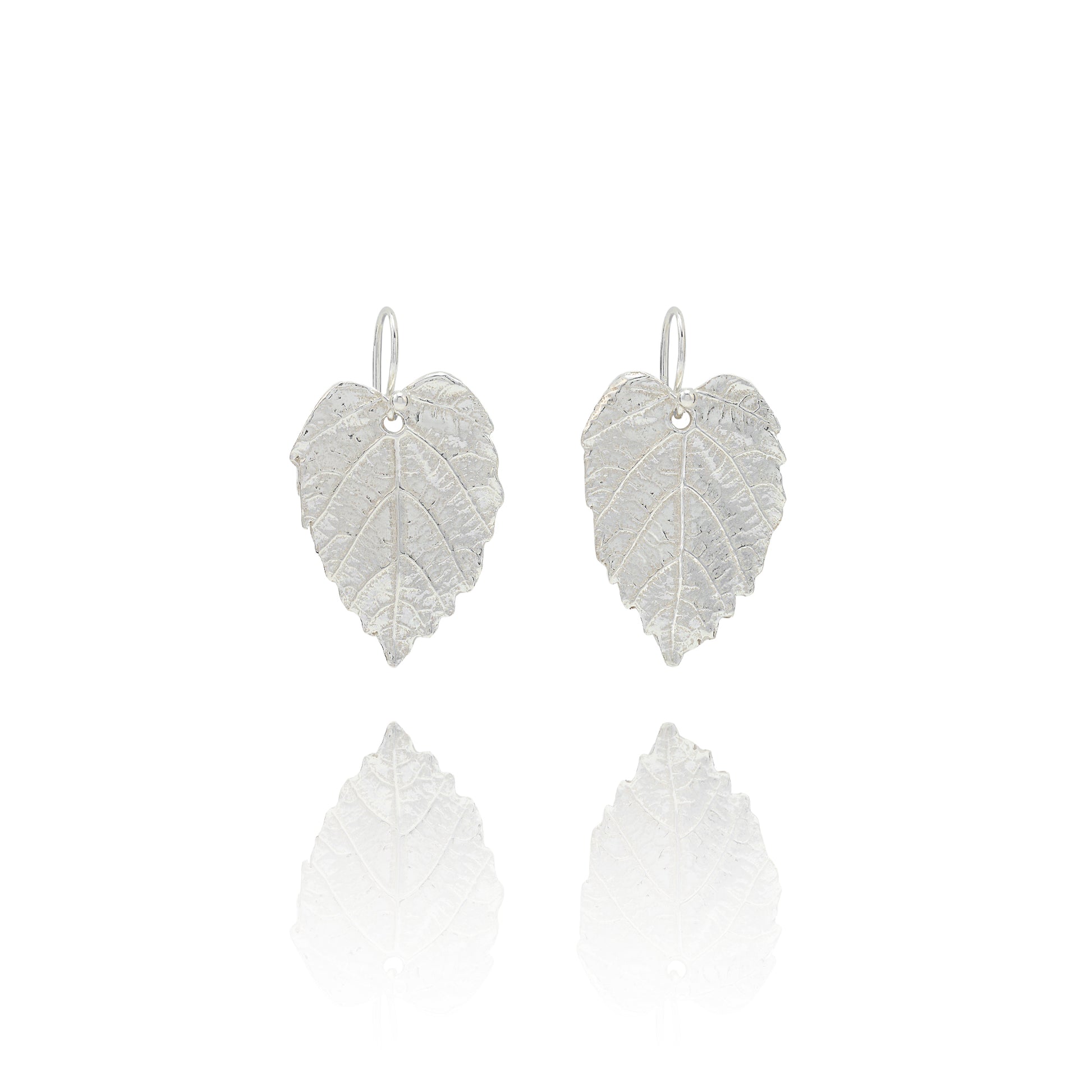 Handmade recycled silver hazel leaf drop earrings by Iris and Lolli on white background, nature inspired and crafted in the UK