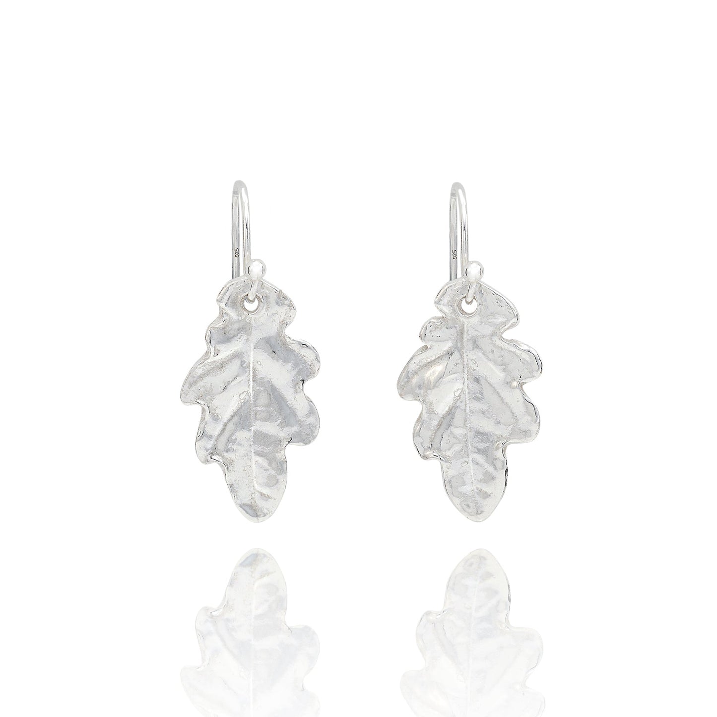 Handmade recycled silver small oak leaf drop earrings by Iris and Lolli on white background, nature inspired and crafted in the UK
