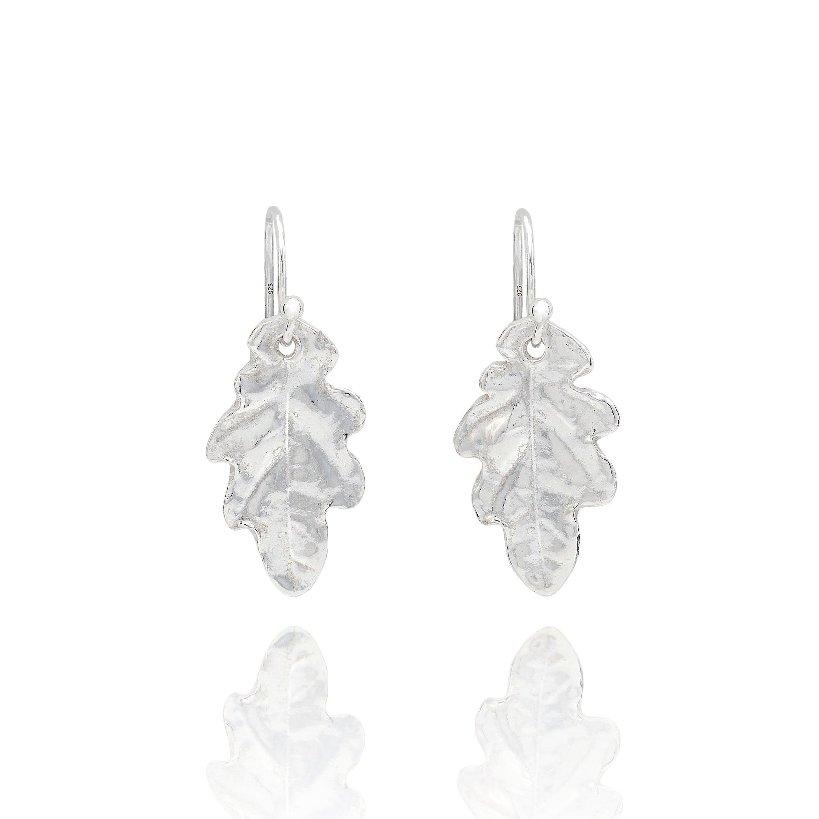 Handmade recycled silver small oak leaf drop earrings by Iris and Lolli on white background, nature inspired and crafted in the UK