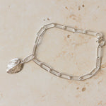 handcrafted recycled silver rose leaf charm bracelet with paperclip chain on stone background, artisan eco silver jewellery by Iris & Lolli
