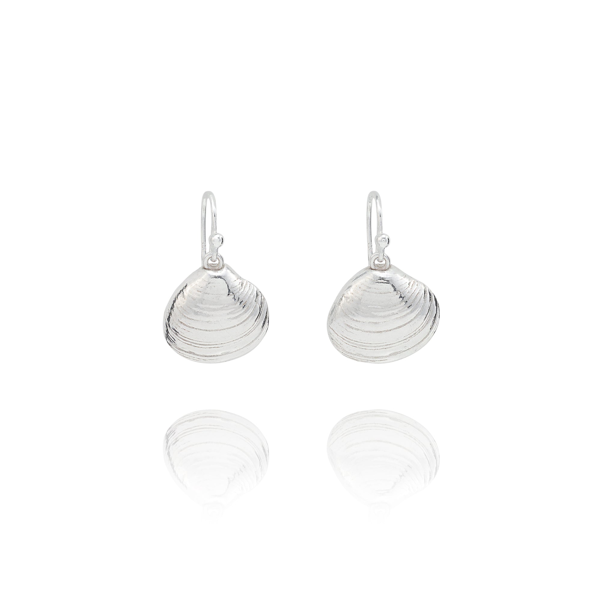 Handmade recycled silver Venus clam shell drop earrings by Iris and Lolli on white background, ocean inspired and crafted in the UK