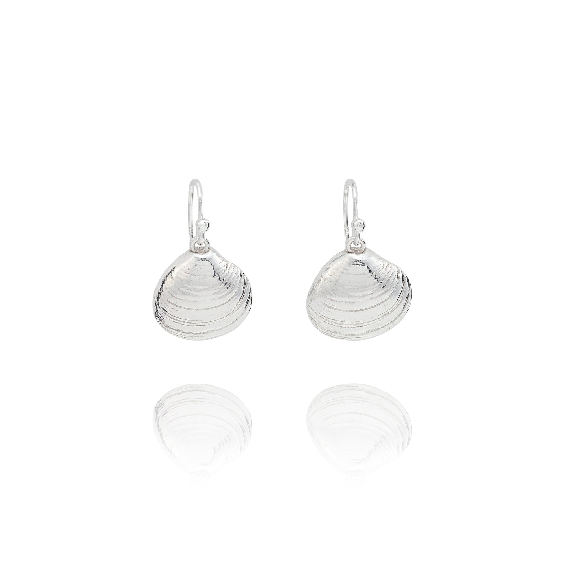 Handmade recycled silver Venus clam shell drop earrings by Iris and Lolli on white background, ocean inspired and crafted in the UK