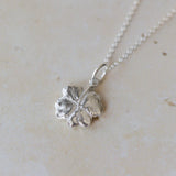 Handcrafted silver clover leaf necklace made from recycled silver. Organic textured pendant with botanical detail, a meaningful lucky clover jewellery gift.