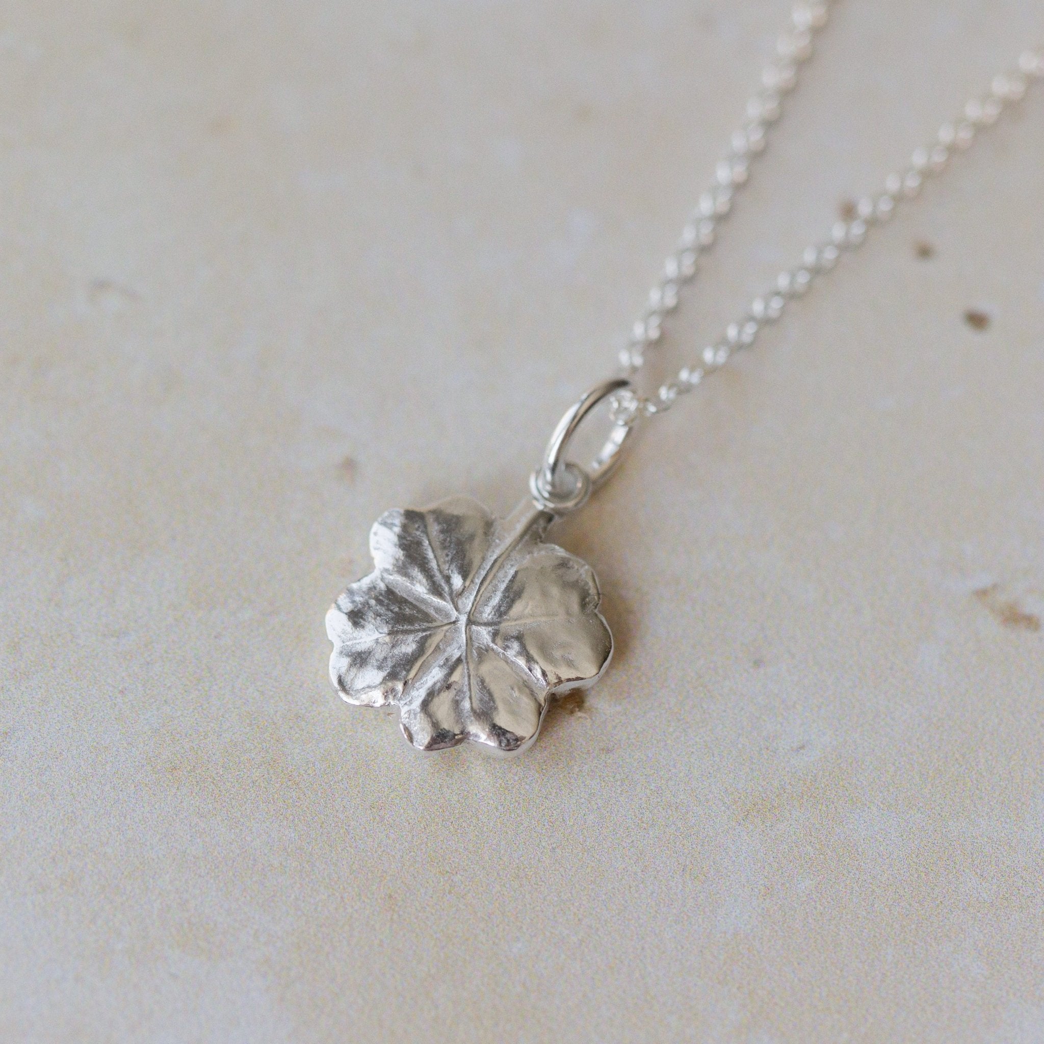 Handcrafted silver clover leaf necklace made from recycled silver. Organic textured pendant with botanical detail, a meaningful lucky clover jewellery gift.