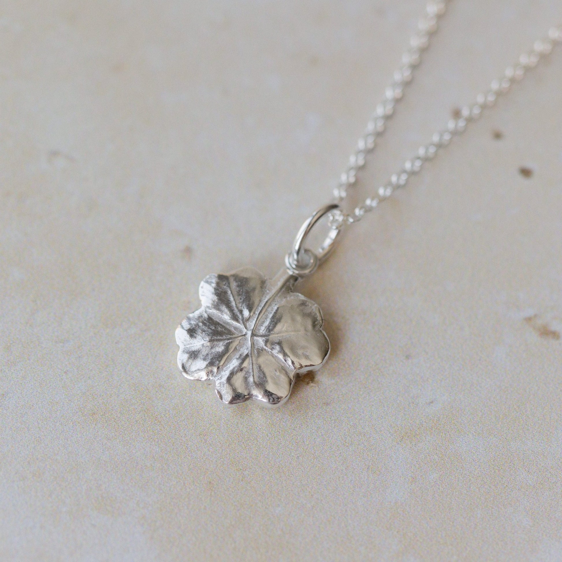 Handcrafted silver clover leaf necklace made from recycled silver. Organic textured pendant with botanical detail, a meaningful lucky clover jewellery gift.