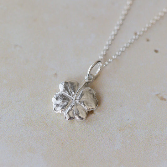 Handcrafted silver clover leaf necklace made from recycled silver. Organic textured pendant with botanical detail, a meaningful lucky clover jewellery gift.