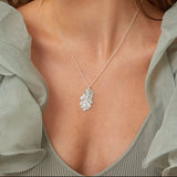 Model wearing a silver oak leaf necklace and silver willow leaf earrings