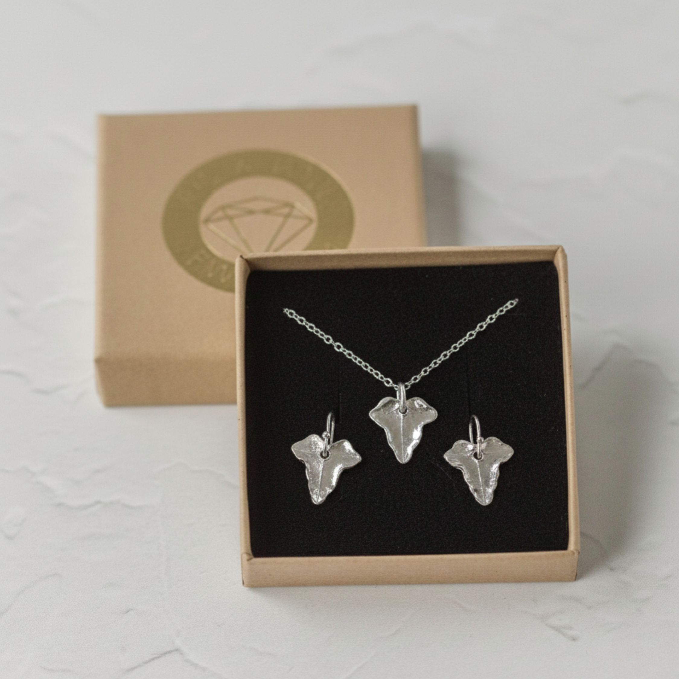 Silver ivy leaf necklace and matching earrings set displayed in a gift box