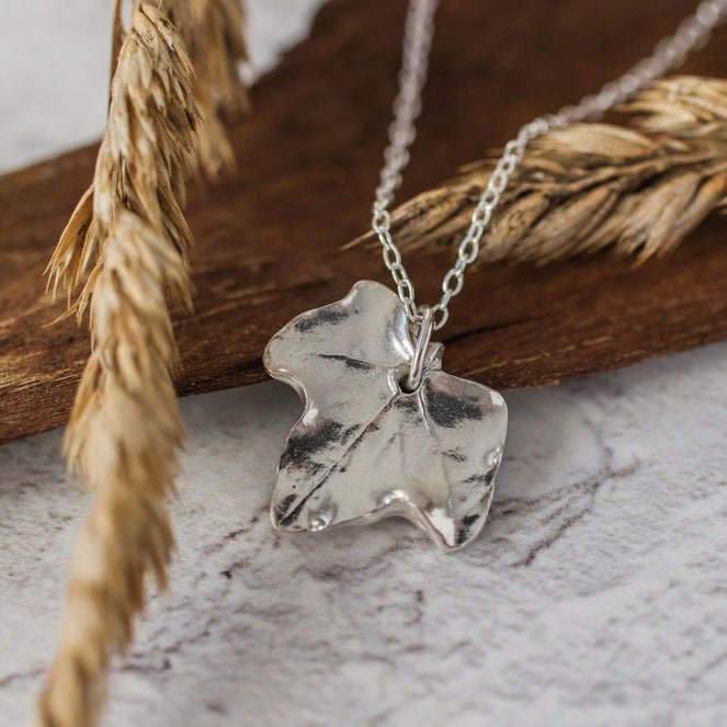 Botanical silver ivy leaf pendant necklace styled with natural textures, eco friendly artisan silver jewellery UK
